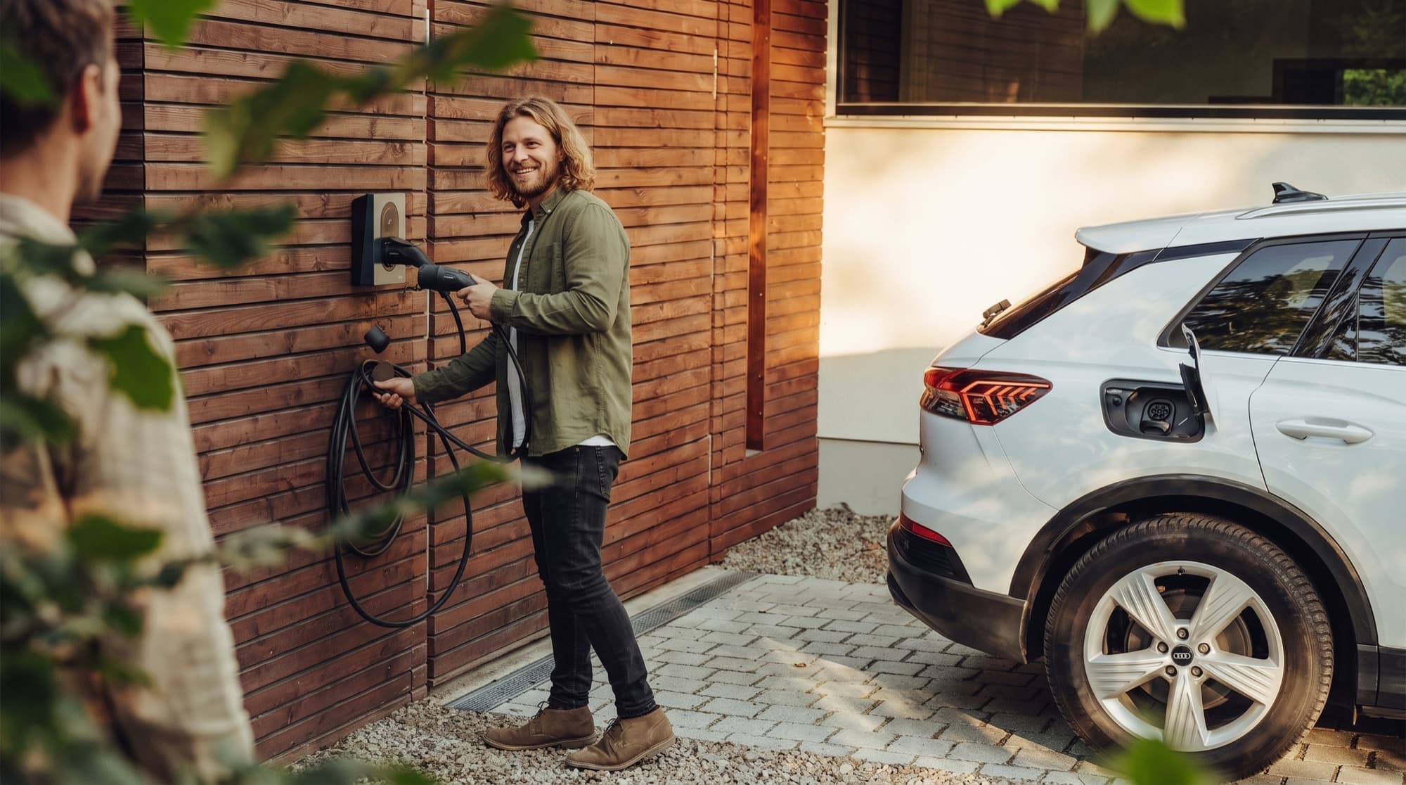 Eine Person lädt ihr E-Auto an einer privaten Wallbox zuhause