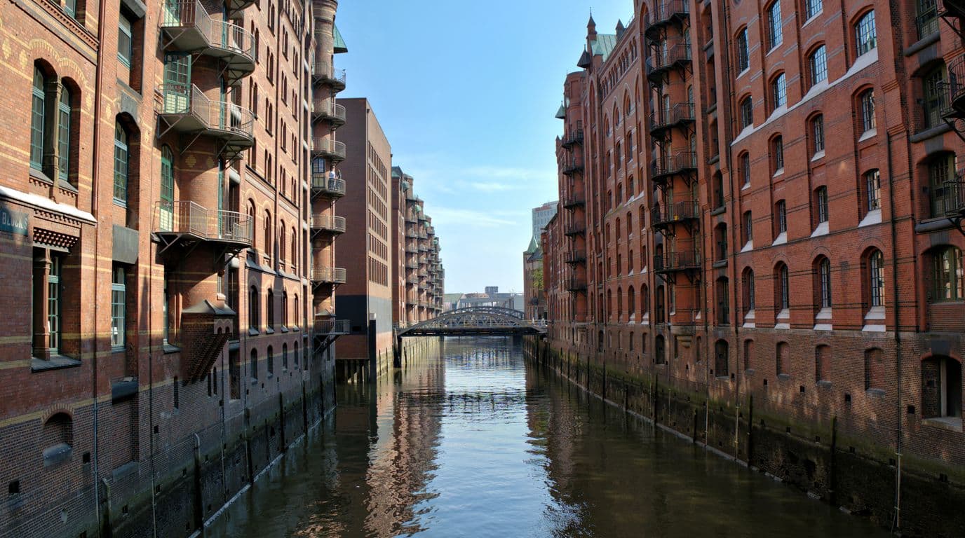Die Hamburger Speicherstadt mit ihren roten Backsteinspeichern am Kanal an einem sonnigen Tag